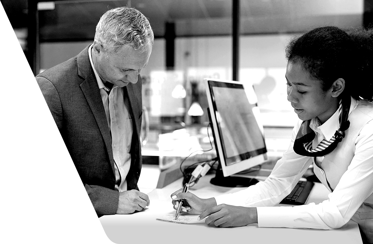 man signing up with woman helping him at her desk