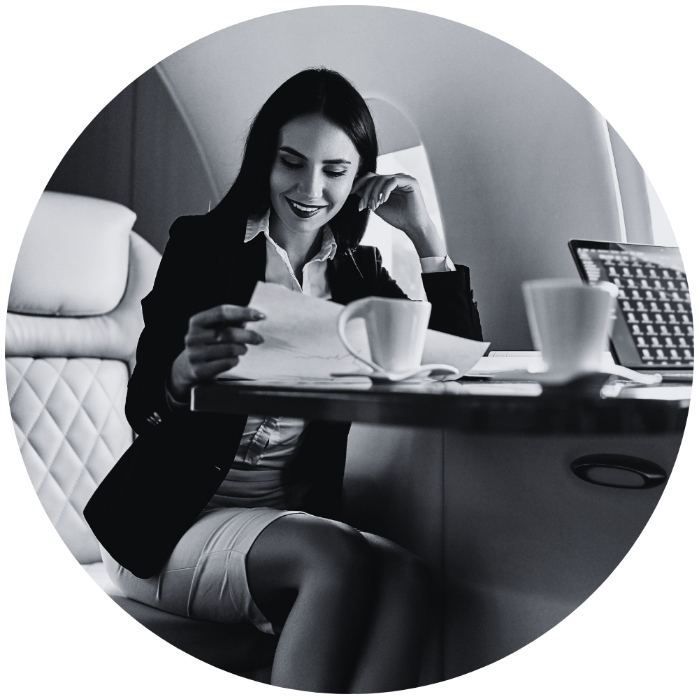 Woman on private jet reviewing paperwork.